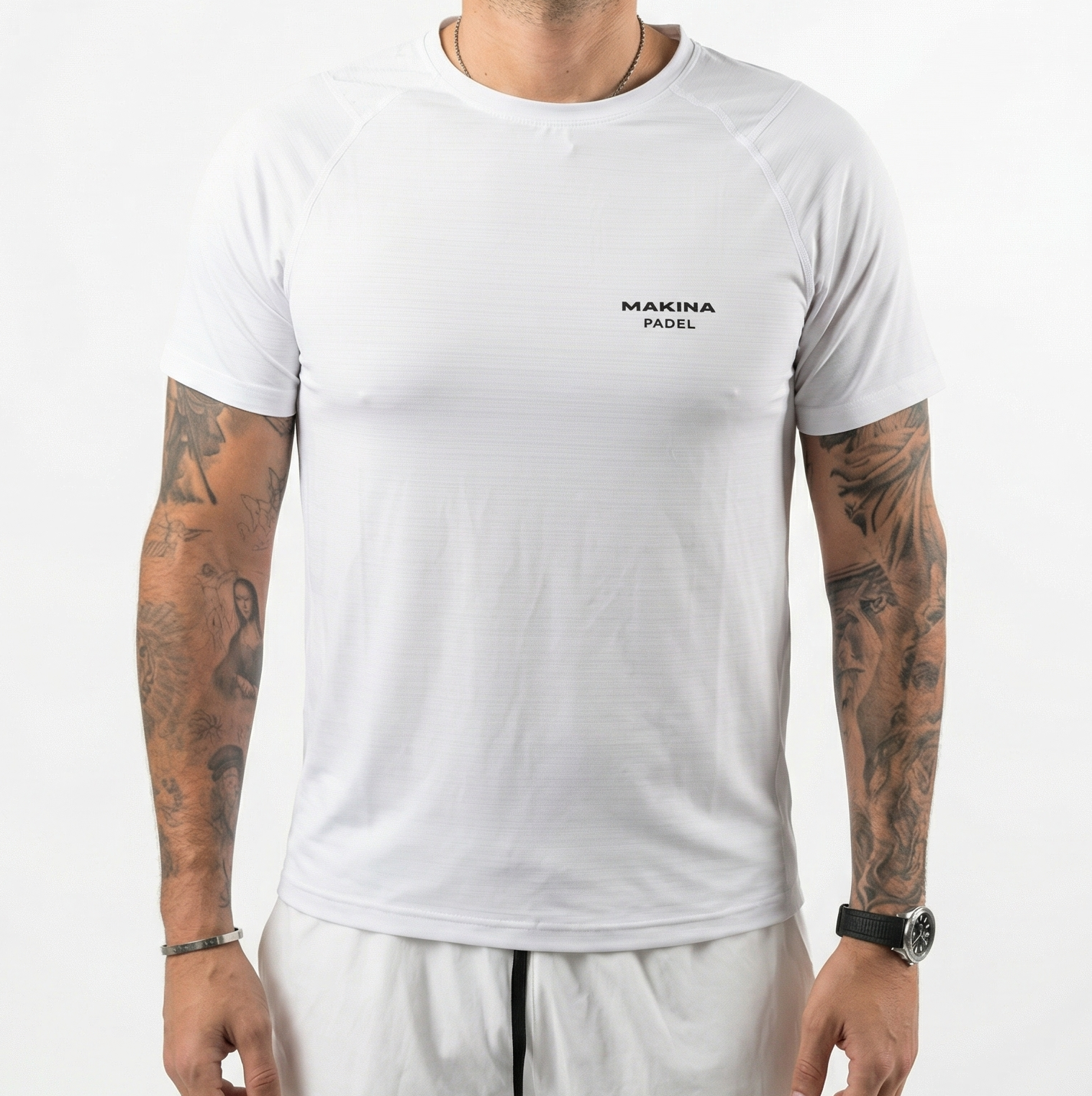Person wearing a white t-shirt with 'MAKINA PADEL' logo on a plain background